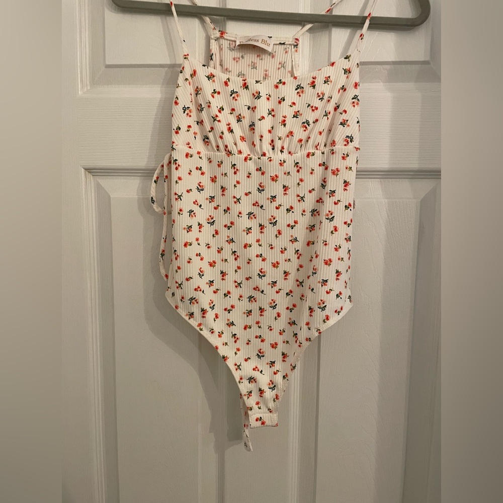 Body suit, white with small flowers. Never worn, still has tags.